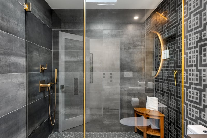 Step into your luxurious spalike bathroom featuring a stunning glassenclosed shower with modern fixtures and bold geometric wallpaper.