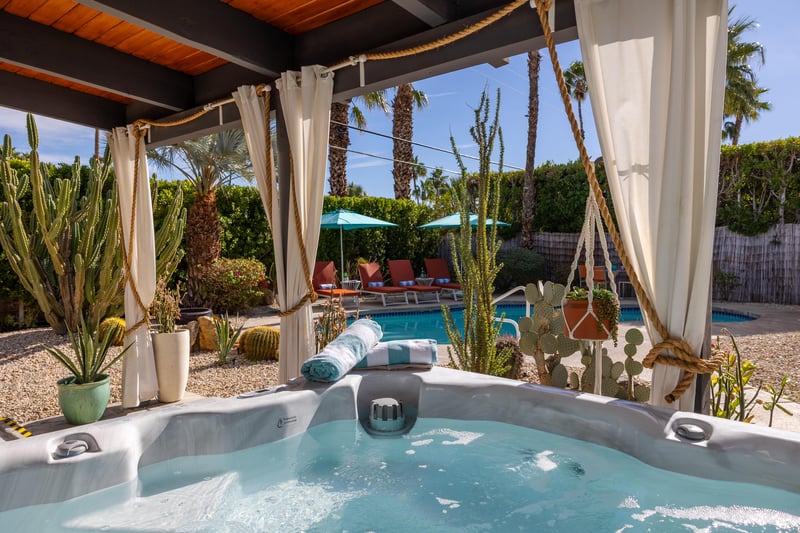 Slip into your private hot tub surrounded by desert palms and cacti, with the sparkling pool just steps away for the perfect oasis retreat.