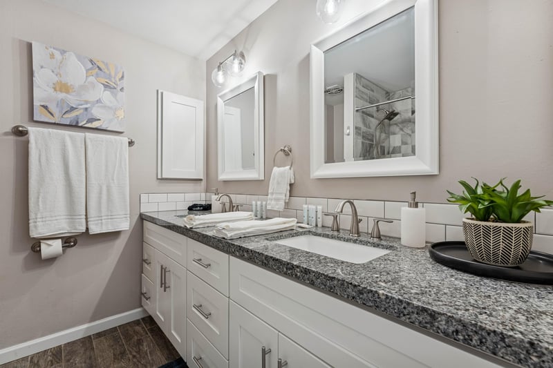 Hallway guest bathroom with dual sinks.