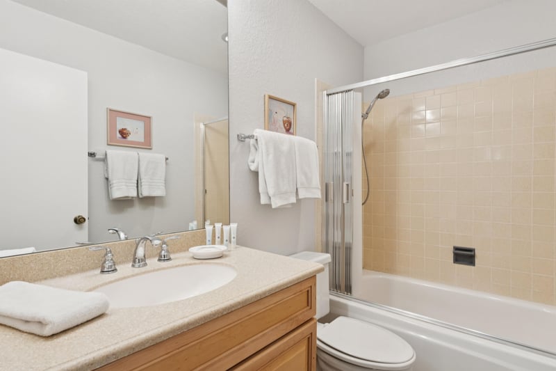 Hallway bathroom is stocked with fresh towels, a starter set of amenities, and features a convenient handheld shower head.