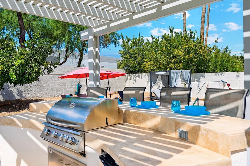 Outdoor kitchen w 4 bar stools and pergola