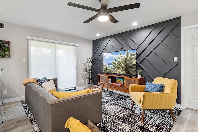 Living Room. Faux leather sofa, mustard sitting chair, clear coffee table, 65 Smart TV w Streaming