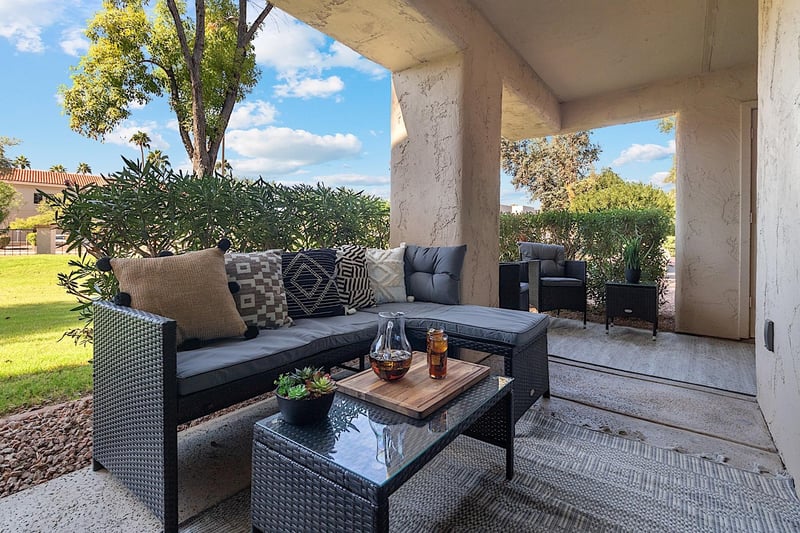 Private patio w Lshaped outdoor sofa, coffee table and two sitting chairs.