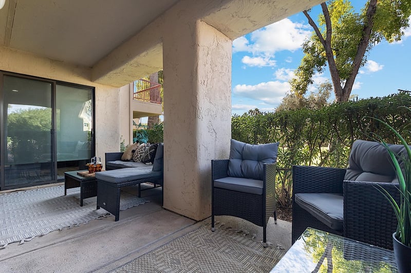 Private patio w Lshaped outdoor sofa, coffee table and two sitting chairs.