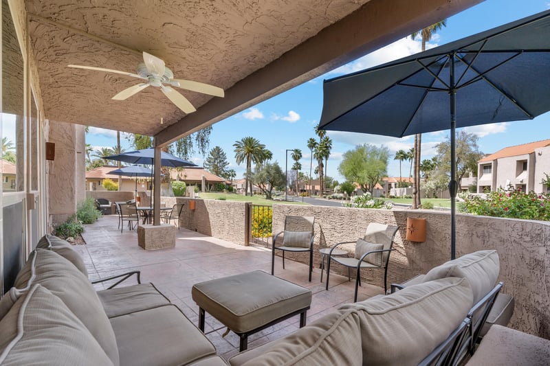 A sprawling and spacious patio for your leisure, that opens up to a large grass area.