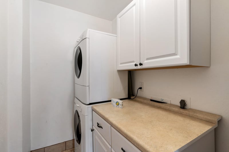 Laundry room is readily available for guest use with the stacked washer and dryer.