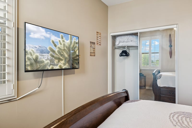 Guest bedroom offers a mounted flatscreen TV and ample storage, with bonus drawers tucked beneath the bed