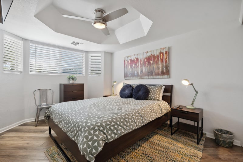 A vaulted ceiling and warm colored accents make this bedroom a calming retreat