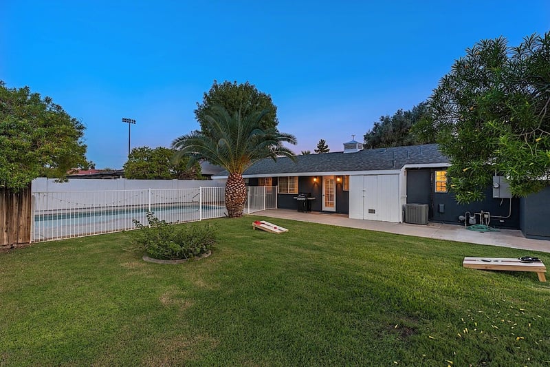 Large grassy backyard with yard games