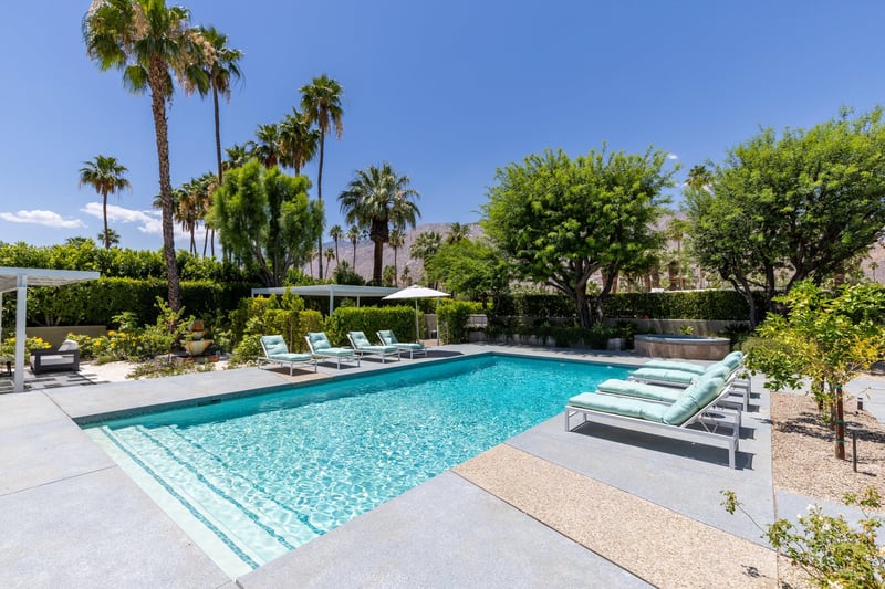 Private poolspa with sun loungers and umbrellas.