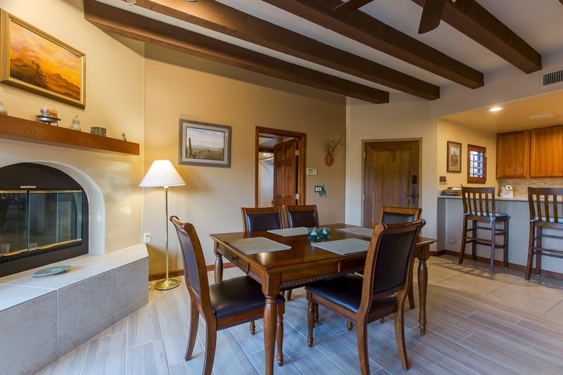 Dining area near the fireplace with a table and chairs for 5 guests.
