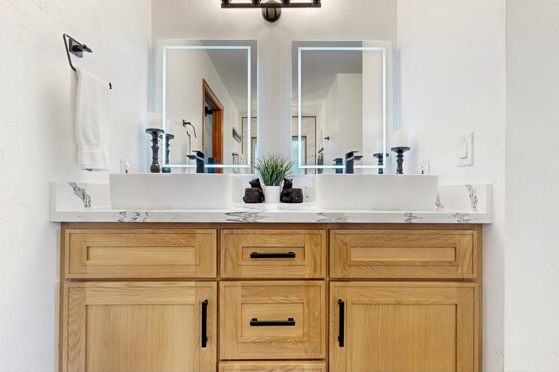 Ensuite bathroom with dual vanity sinks, modern fixtures, standalone tub, and walkin shower.
