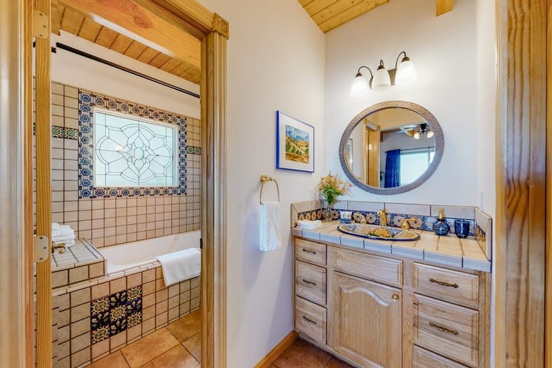 Sink and Mirror are separate for from toilet and, large tub and shower. All featuring custom tile.
