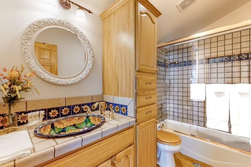 Located between the upstairs bedrooms featuring tub shower and custom tile throughout.