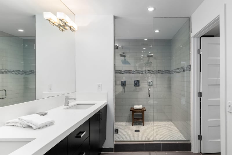 En suite bathroom featuring a walkin shower and dual sink vanity.