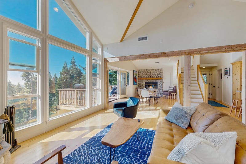 Large windows and vaulted ceilings. Dining area and 2nd fireplace can be seen.