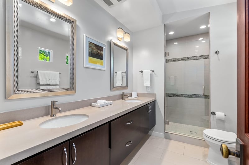 Ensuite bathroom with dual vanity sink, walkin closet, and standalone shower.