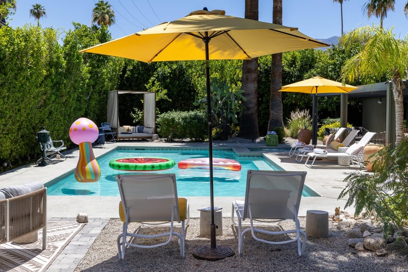 Entertainers backyard with outdoor seating, private pool and spa, sun loungers, cabana, and outdoor dining space.