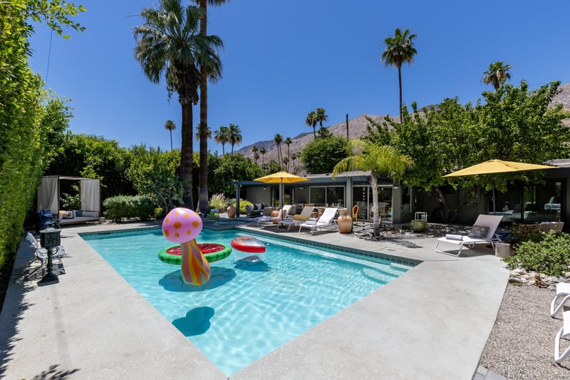 Entertainers backyard with outdoor seating, private pool and spa, sun loungers, cabana, and outdoor dining space.