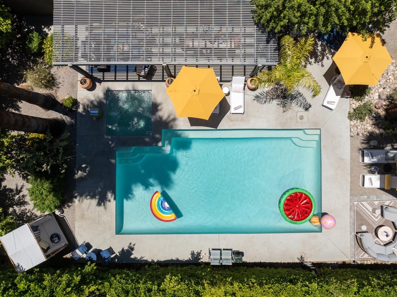 Entertainers backyard with outdoor seating, private pool and spa, sun loungers, cabana, and outdoor dining space.