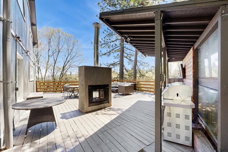The deck area is perfect for entertaining with a wet bar, outdoor seating, and an outdoor fireplace.