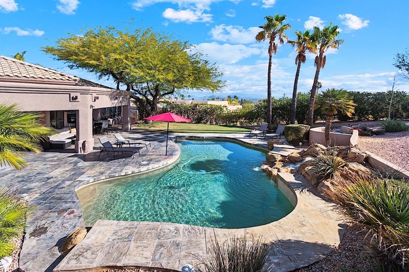 Big backyard with heated pool, sun loungers, outdoor kitchen, playground and mountain views