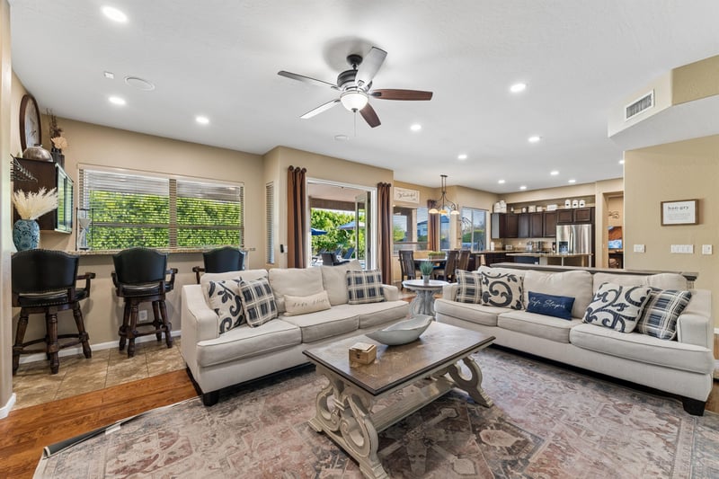 Living room features plenty of seating, additional sleeping space with pullout sofa beds, flatscreen TV with streaming, fireplace, and patio access.