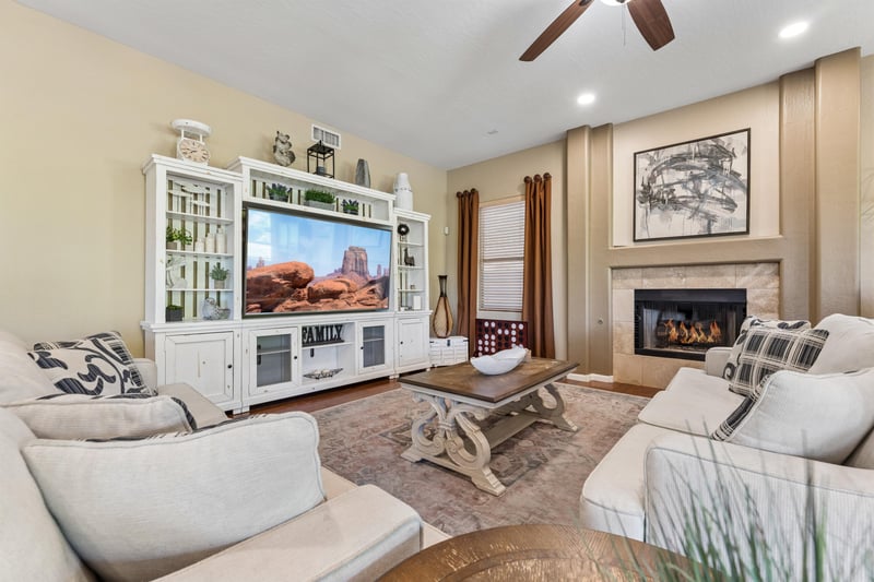 Living room features plenty of seating, additional sleeping space with pullout sofa beds, flatscreen TV with streaming, fireplace, and patio access.