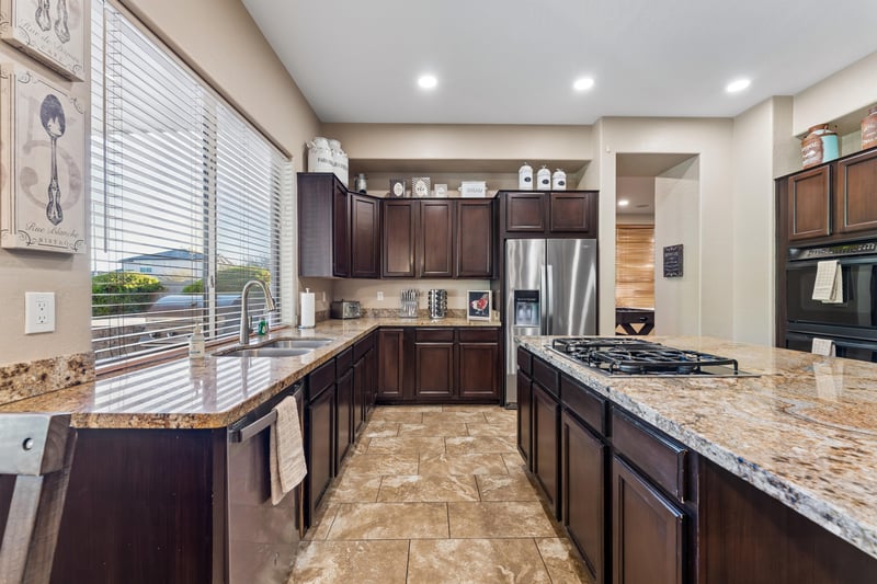 Chefs kitchen with large island, plenty of counter space, and stainless steel appliances.