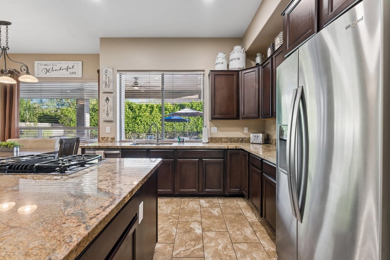 Chefs kitchen with large island, plenty of counter space, and stainless steel appliances.
