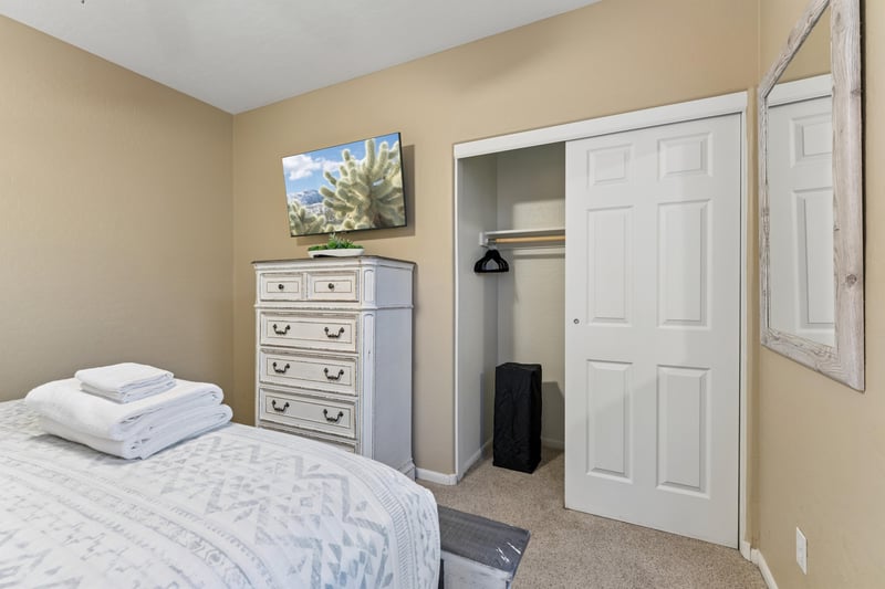 Queen size bed, flatscreen TV, and closet space.