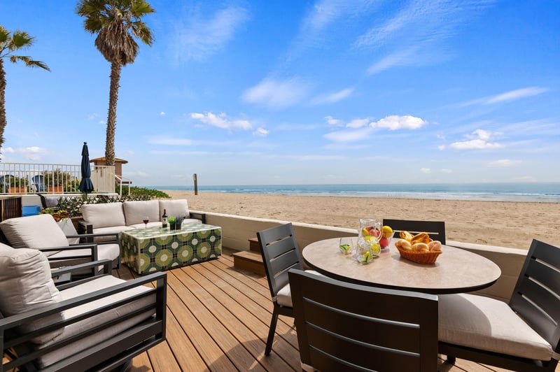 Toes in the sand Deck with comfortable couch, chairs, and dining area.