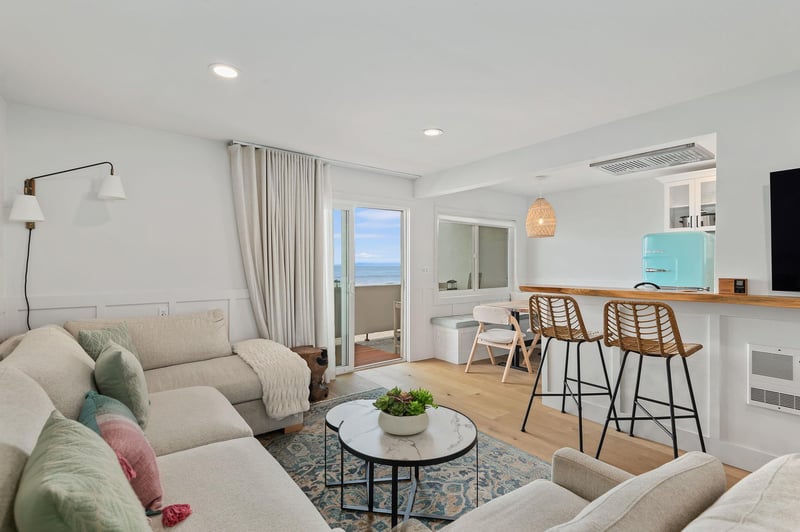 Living room with sectional sofa, breakfast bar, flat screen TV and ocean views.
