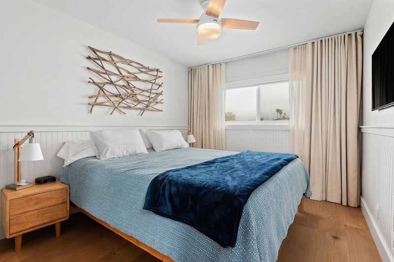 The master bedroom has a California King, flat screen TV, shades, curtains, and a ceiling fan.