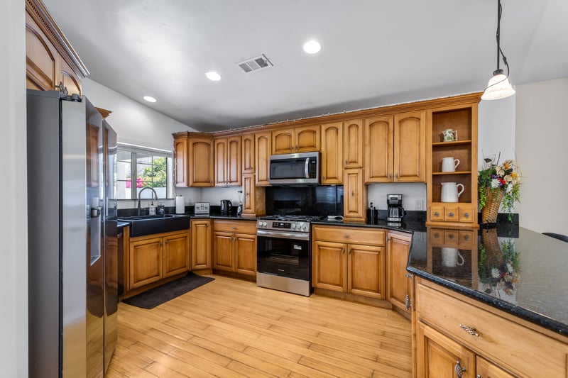 Stainless steel appliances, coffee maker, granite counters, and counter seating for 4 guests.