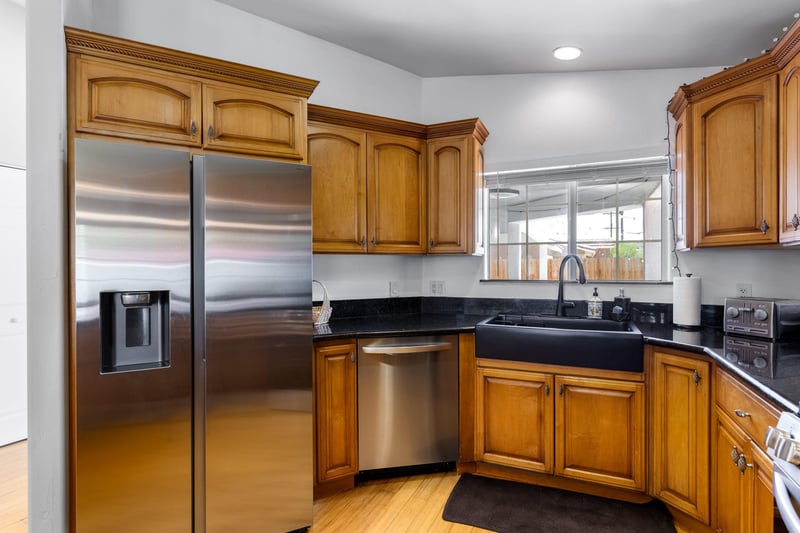 Stainless steel appliances, coffee maker, granite counters, and counter seating for 4 guests.