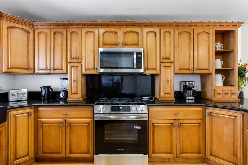 Stainless steel appliances, coffee maker, granite counters, and counter seating for 4 guests.