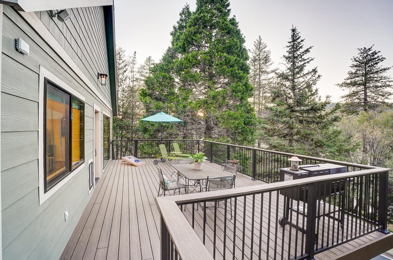 Spacious deck with mountain and forest views, outdoor games, BBQ, and deck seating.