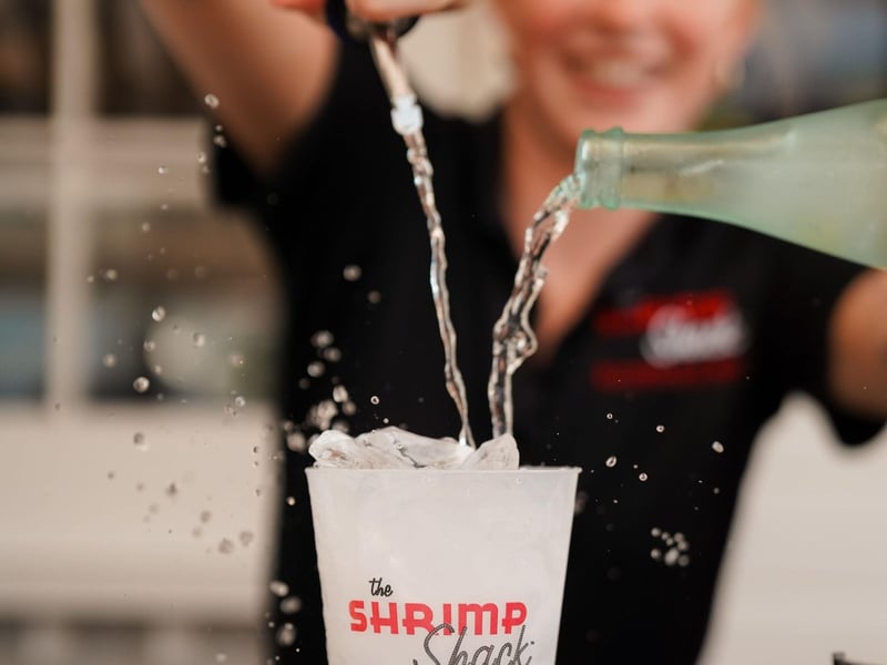 A bartender making a drink at The Shrimp Shack and Boardwalk Bar