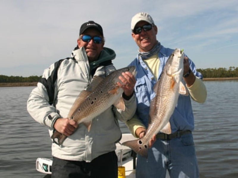 Two fishers showing off their catches with Flyliner Charters in Fort Walton Beach, Florida