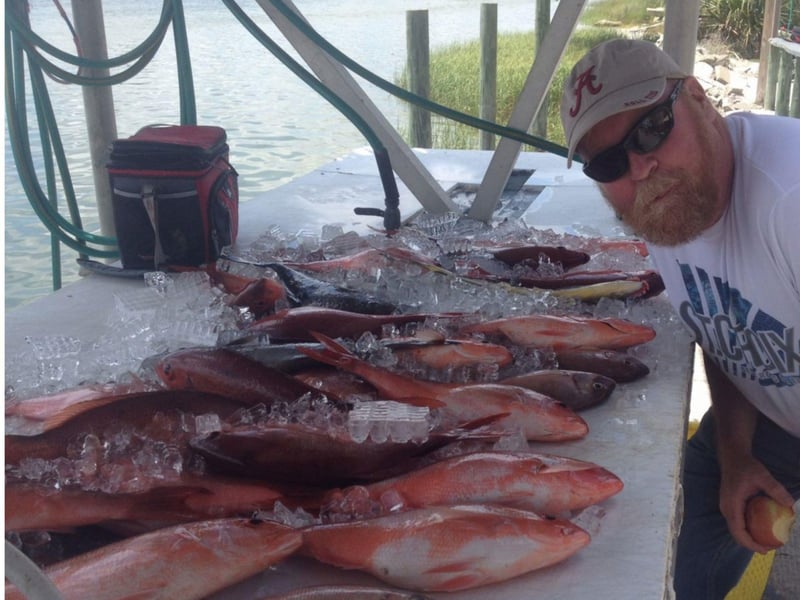 An angler with his catches from Heads n Scales Fishing Charter in Pensacola Beach, Florida