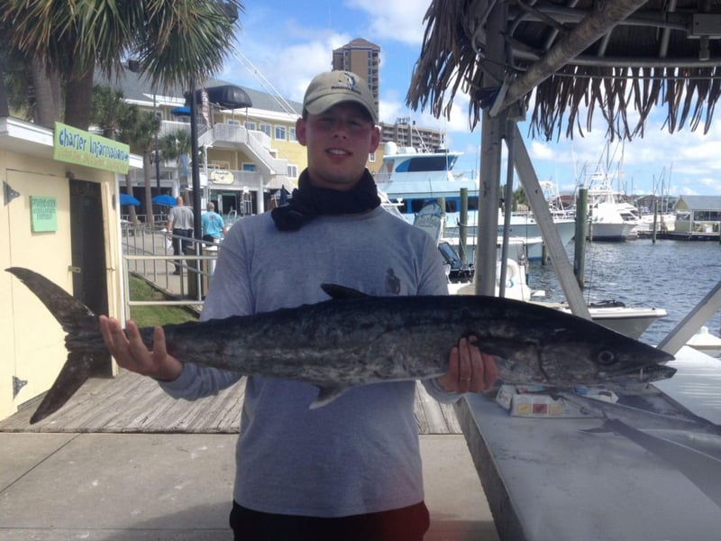 A man showing off his fish on the dock