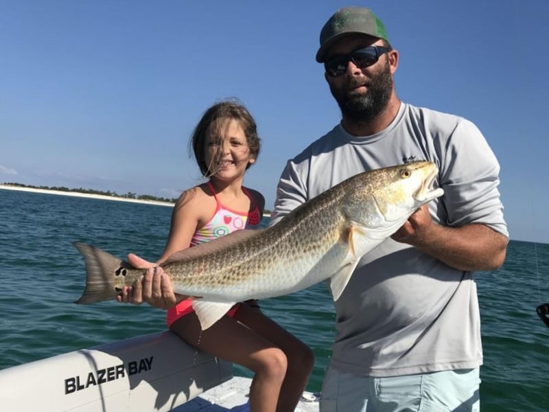 A young girl and her family with her catch