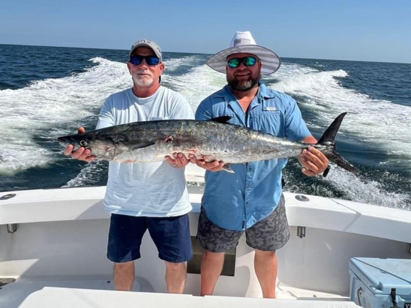Two anglers showing off their fish on the back of Miss Carli