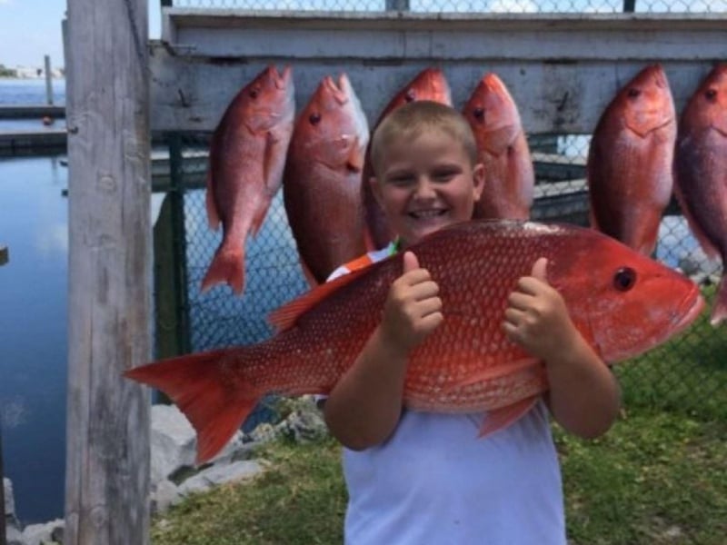 A young fisherman with his red snapper from Pleasure Island Charters