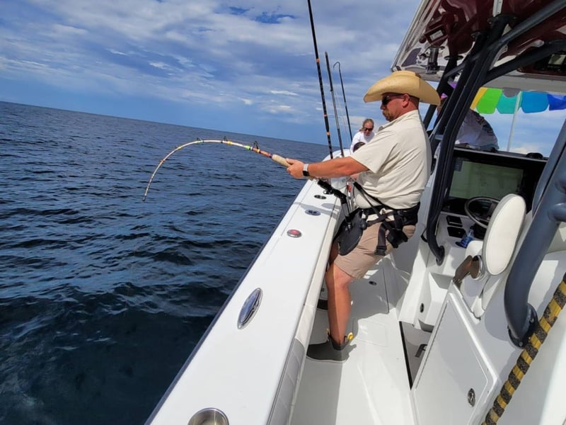 An angler fishing off the side of the boat