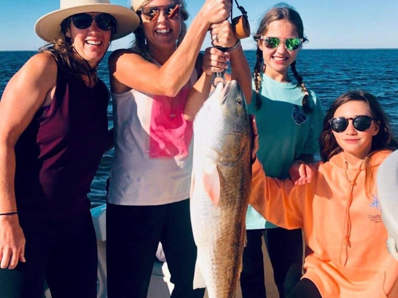 A family showing off their catch from Robinson Brothers Guide Service