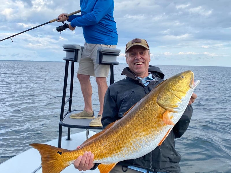 An angler showing off his catch on board the boat