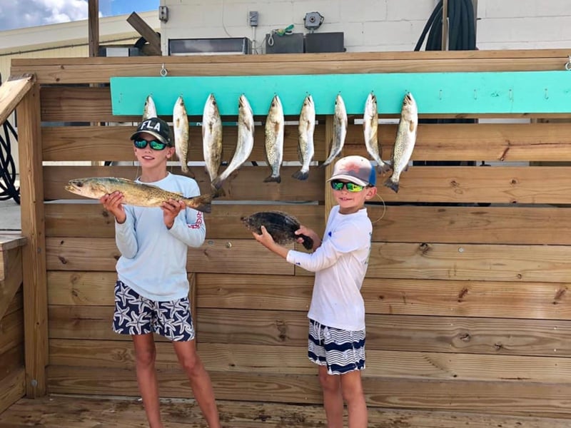 Two young boys with their fish at the dock in Apalachicola, Florida