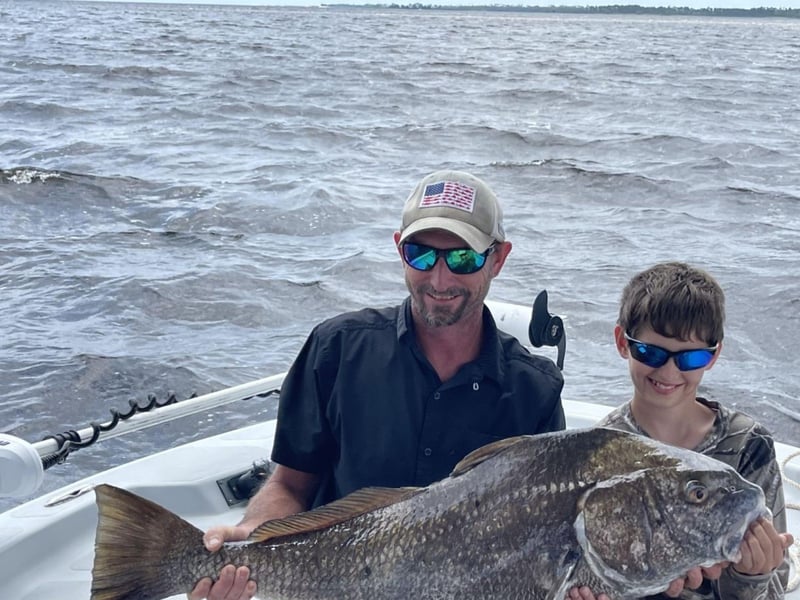 A group showing off their catch on the back of the boat